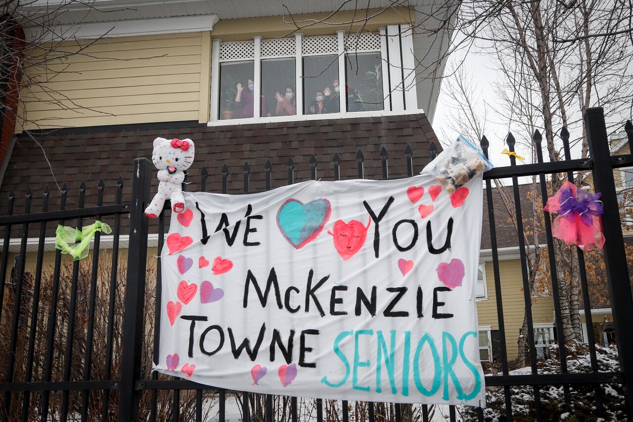 Photo of Residents at the McKenzie Towne Continuing Care Centre in Calgary wave from a distance to loved ones below. (Jeff McIntosh/Canadian Press)